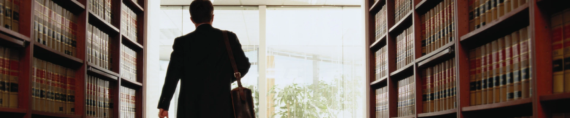 Attorney walking to his office between book shelves